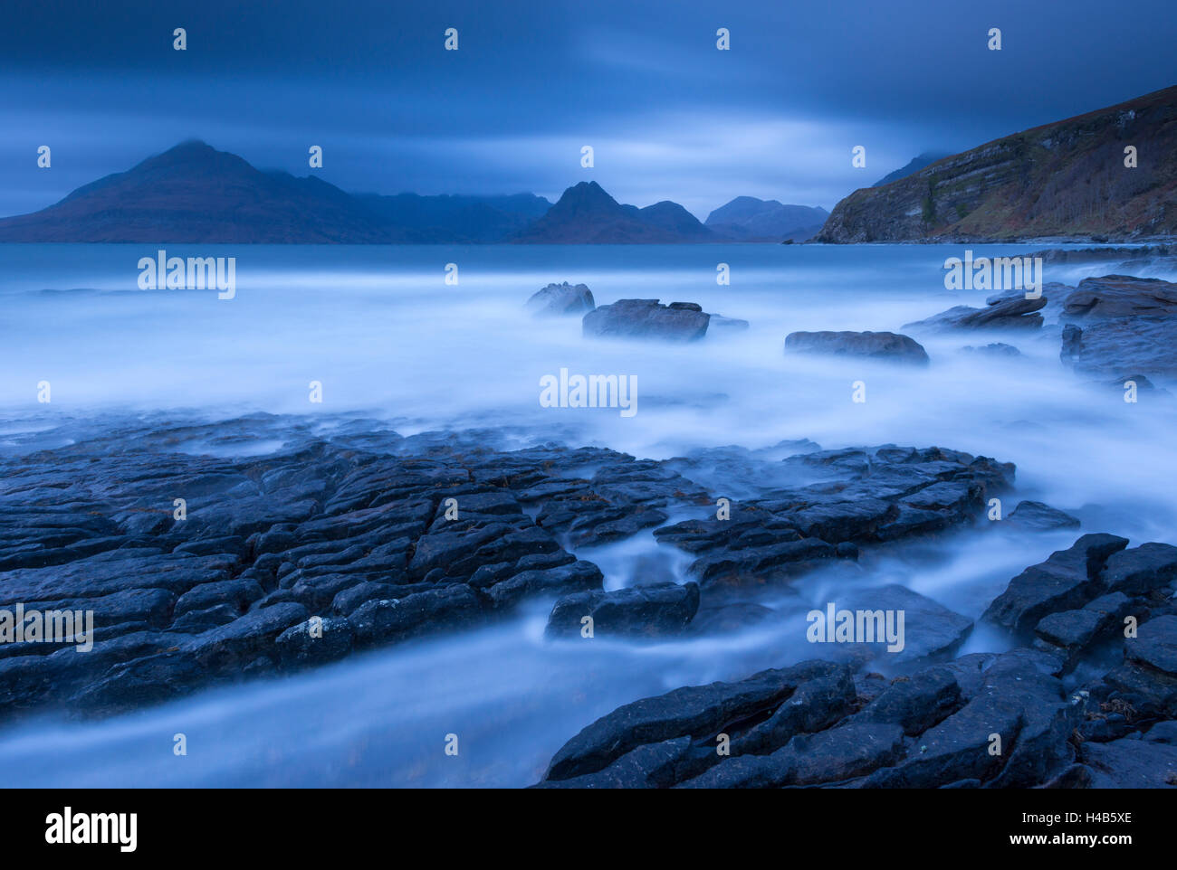 Twilight on the rocky coast of Elgol, looking across to the Cuillin mountains, Isle of Skye, Scotland. Autumn (November) 2012. Stock Photo