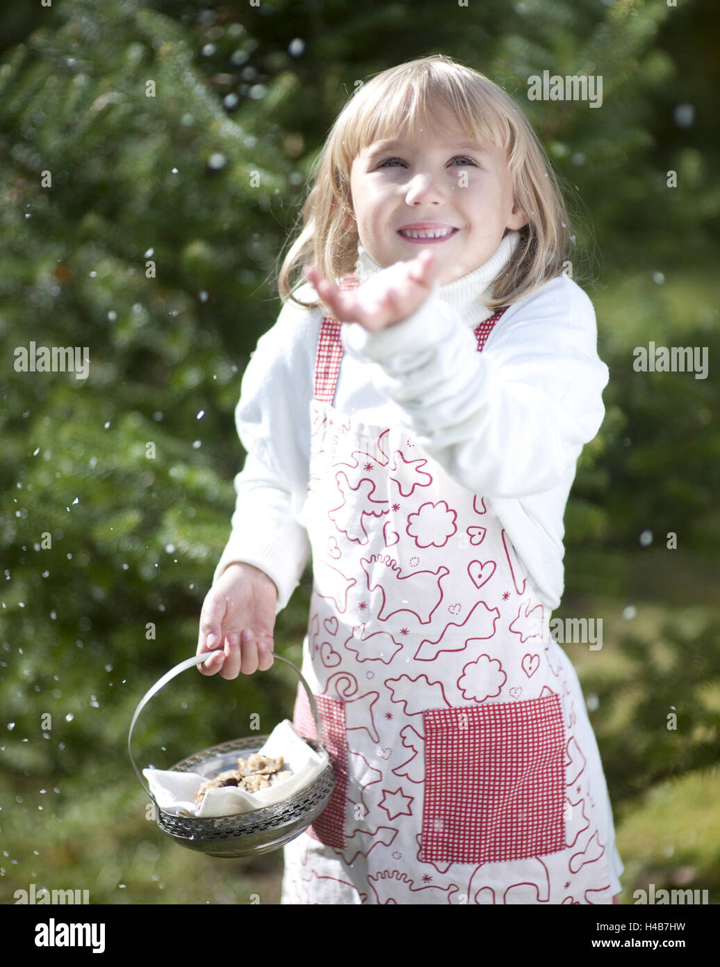 Girl with apron holds peel with little place, snowfall, gesture, half