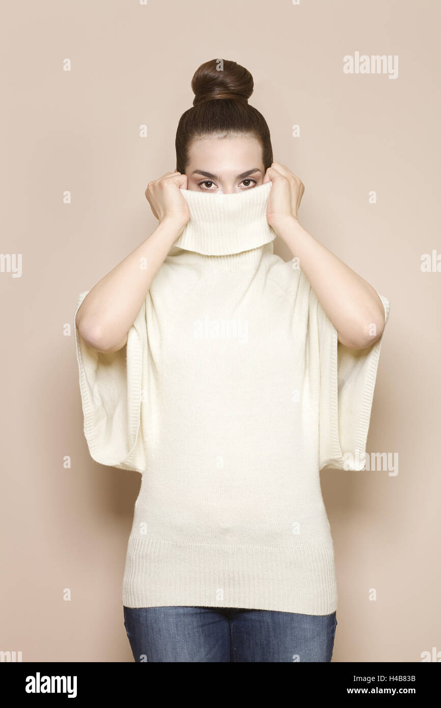 Woman pulls up collar her sweater hires stock photography and images