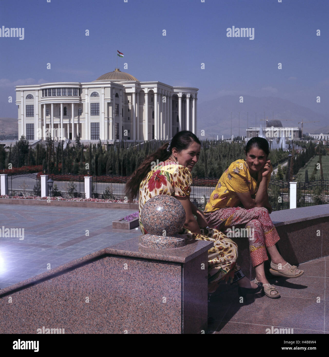 Tajikistan, Duschanbe, two women on Rudaki Prospekt, government building, Stock Photo