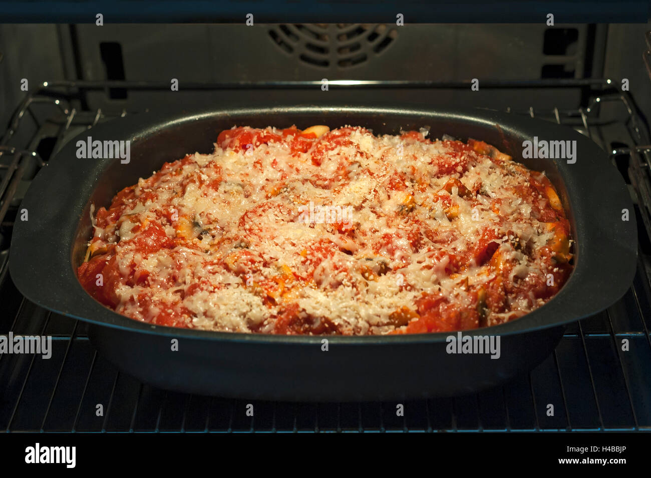 Baked pasta dish with tomato and cheese, in a pan in the oven Stock Photo
