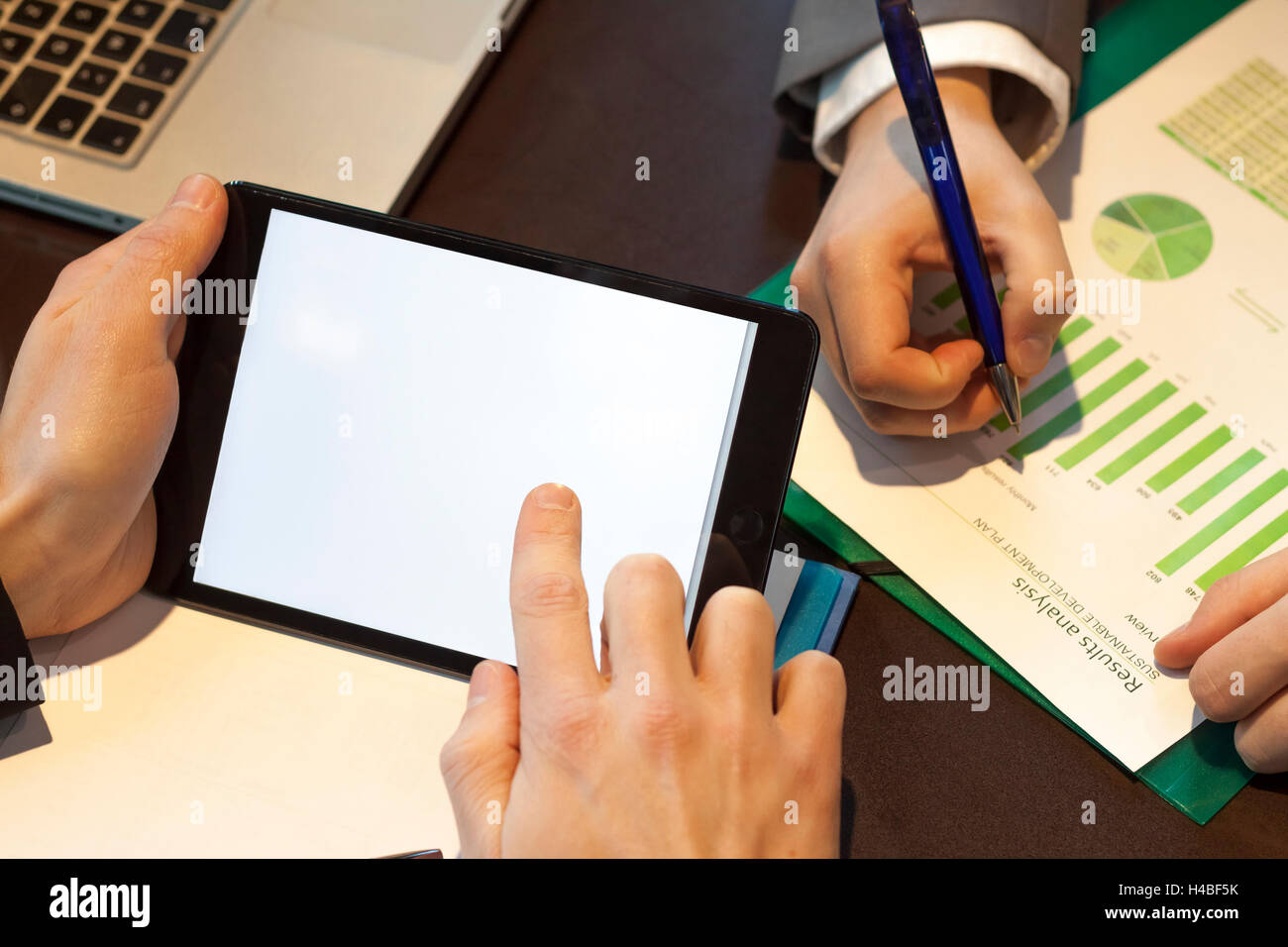 Two businessmen analyzing data with chart tablet and laptop. Finger touching screen Stock Photo