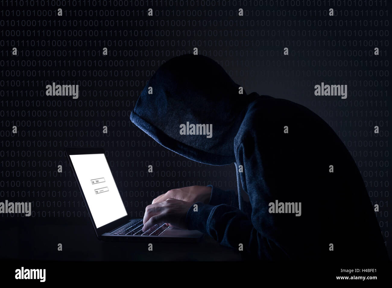 Hacker with laptop initiating cyber attack Stock Photo