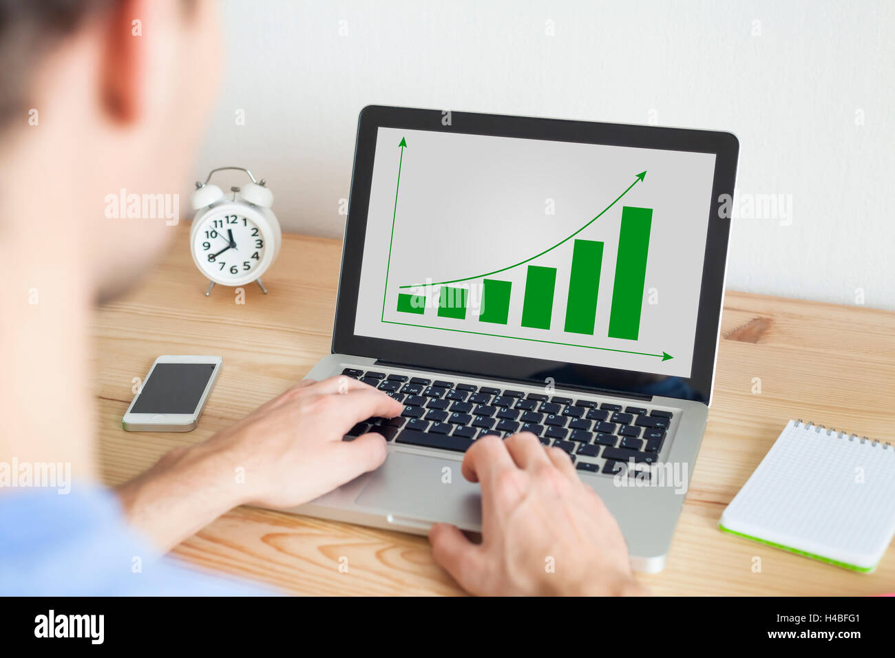 Businessman working at home on laptop and smartphone on sustainable development project Stock Photo