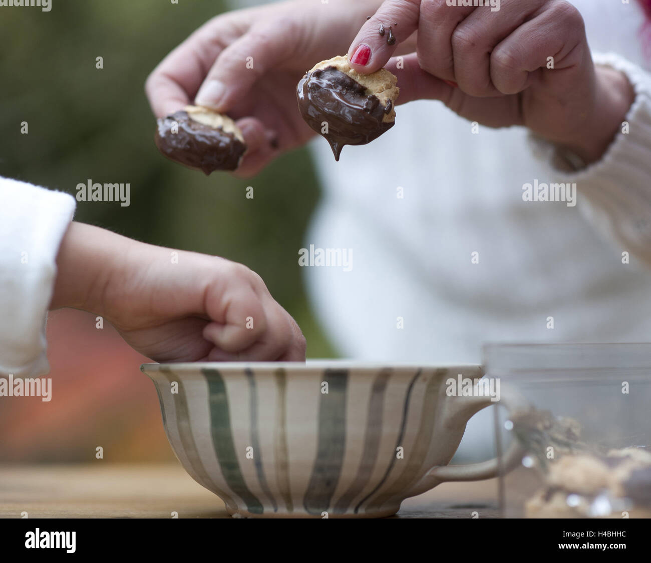 Women, child, baking cookies, dipping in chocolate, close-up, detail, Stock Photo