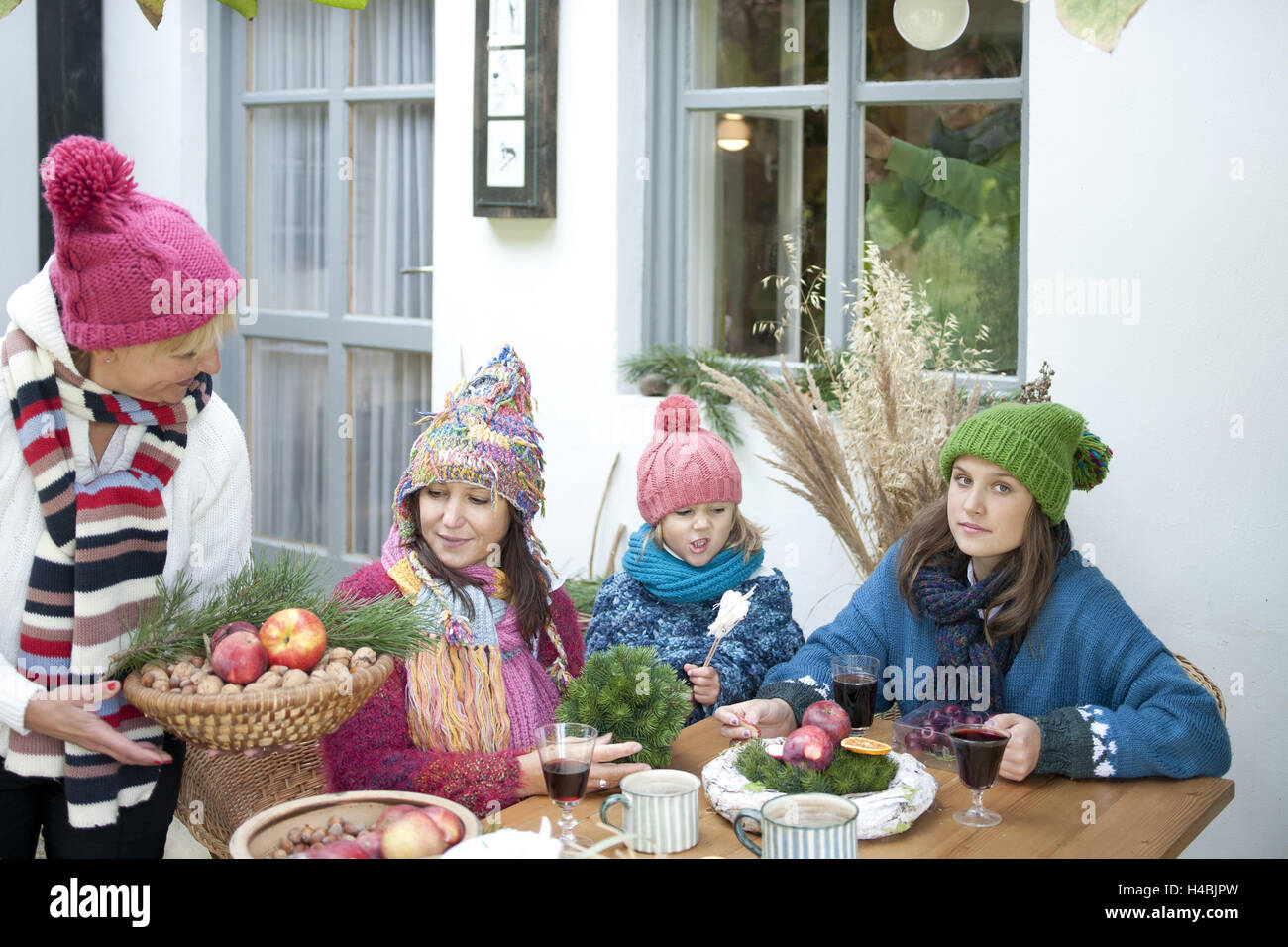 Three women and girls, Christmas decoration on terrace, Stock Photo