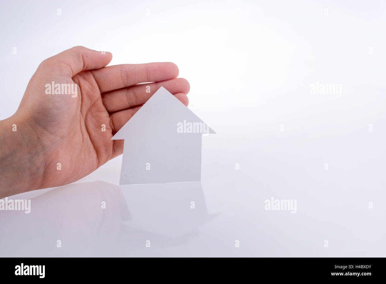 Hand holding a paper house on a white background Stock Photo - Alamy