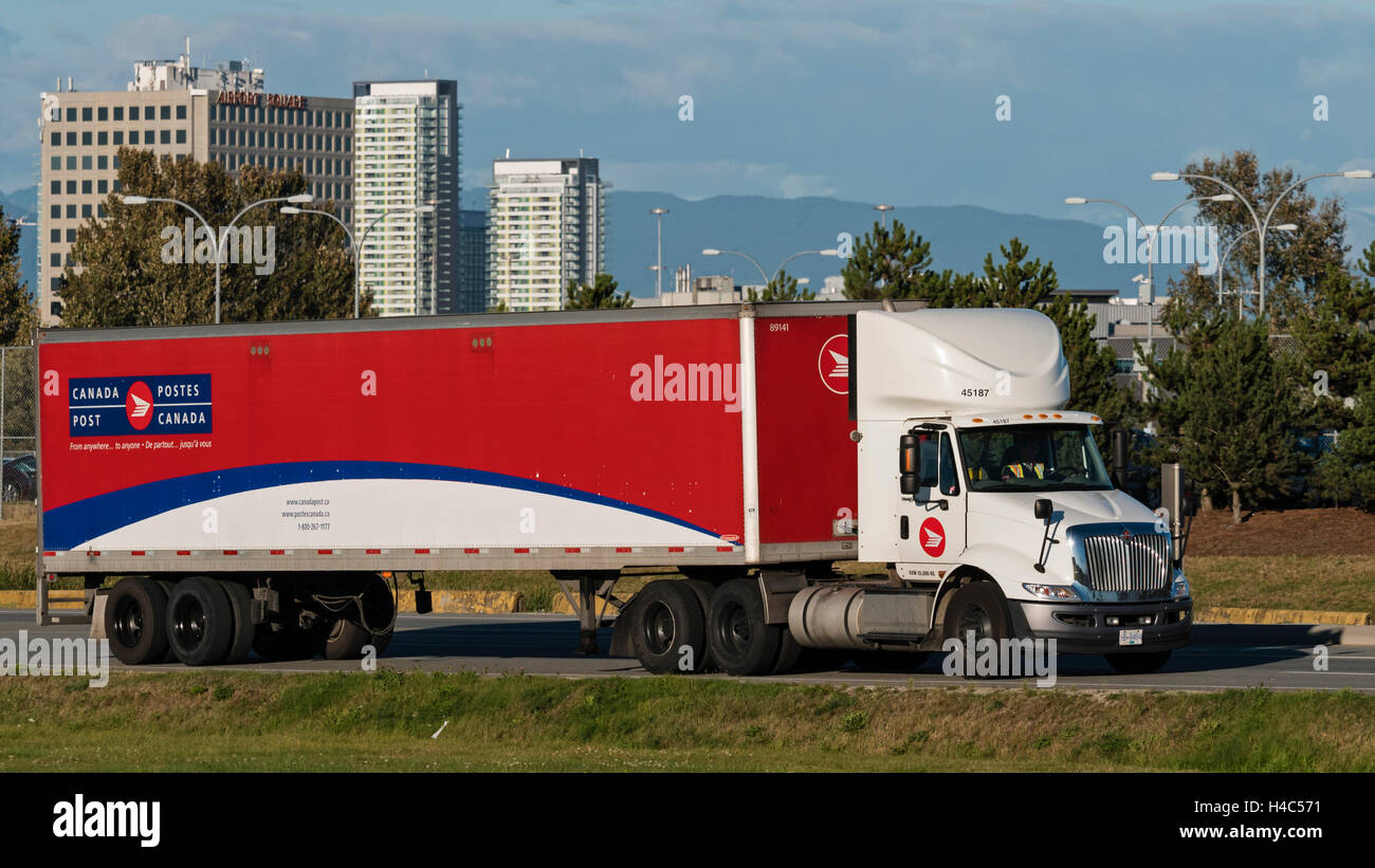 A Canada Post semi tractor trailer transport truck travels along a road, Richmond, British