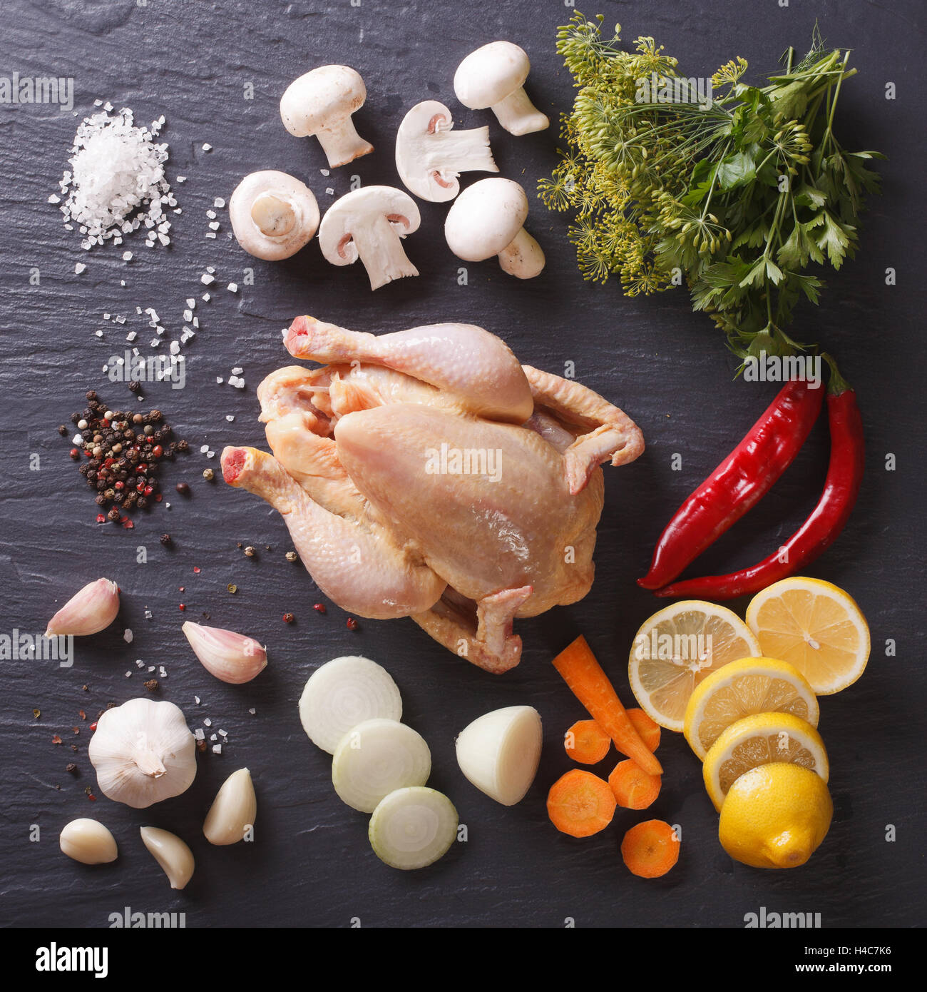 Homemade raw chicken with ingredients for cooking close up on a slate board. view from above Stock Photo