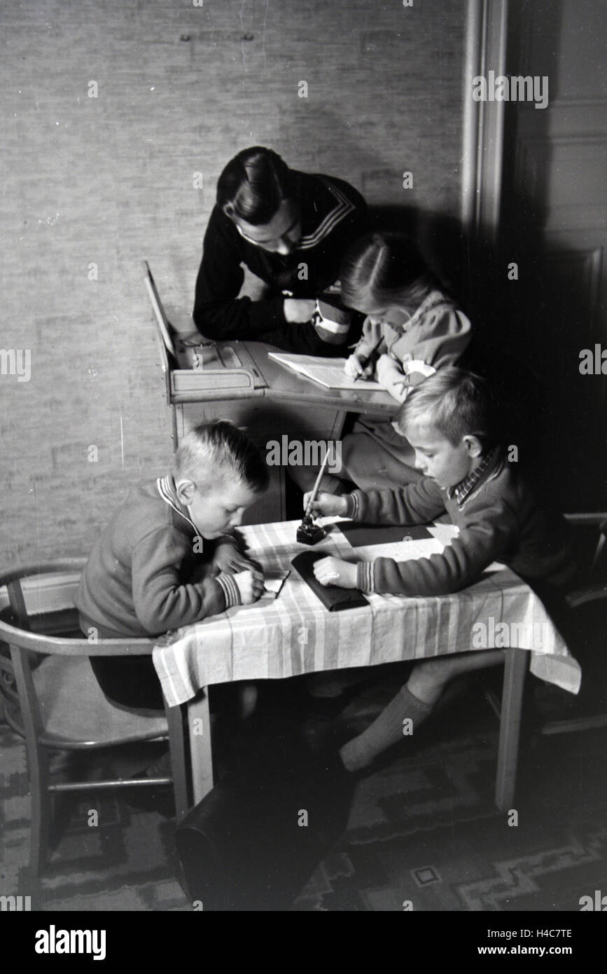 Mitglieder einer kinderreichen Familie helfen sich gegenseitig, Deutsches Reich 1930er Jahre. Members of an extended family helping one another, Germany 1930s Stock Photo