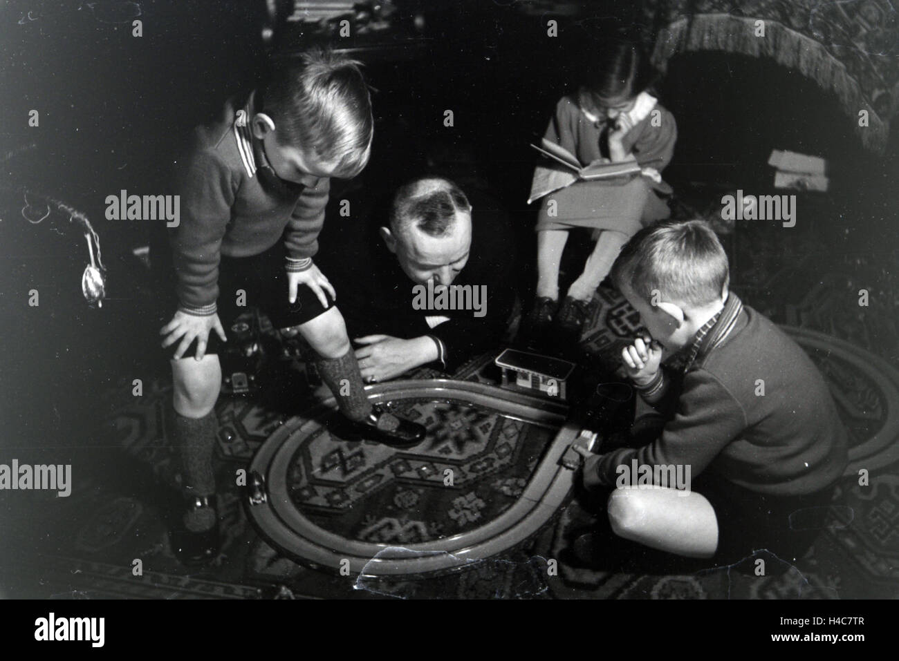 Mitglieder einer kinderreichen Familie spielen im Wohnzimmer, Deutsches Reich 1930er Jahre. Members of an extended family playing in the living room, Germany 1930s Stock Photo