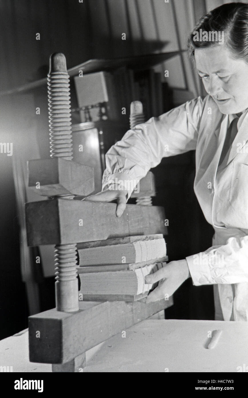 Eine Buchbinderin bei der Arbeit, Deutsches Reich 1930er Jahre. A bookbinder at work, Germany 1930s, Stock Photo