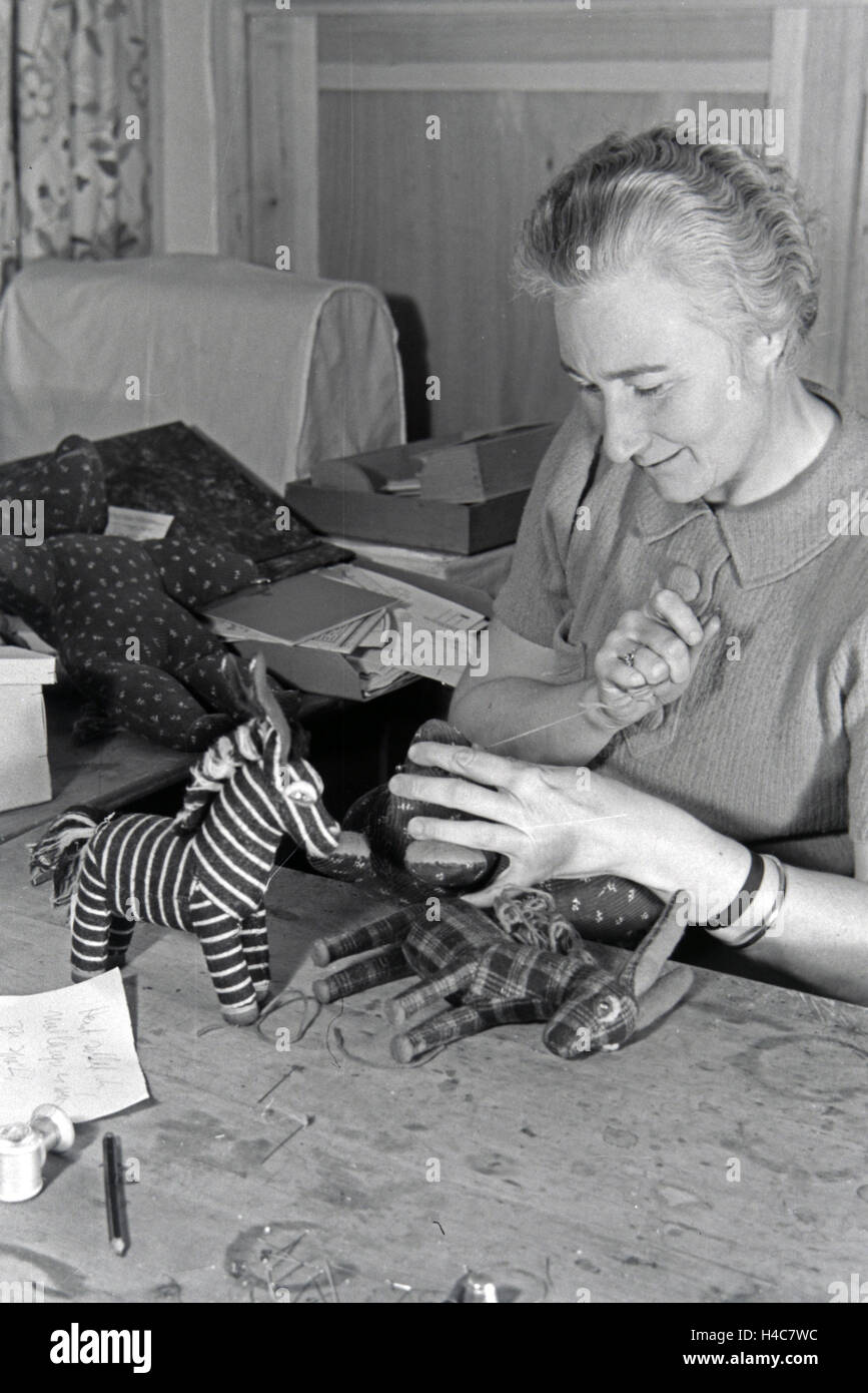 Eine Kunsthandwerkerin näht Plüschtiere, Deutsches Reich 1930er Jahre. An artisan sewing cuddly toys, Germany 1930s Stock Photo