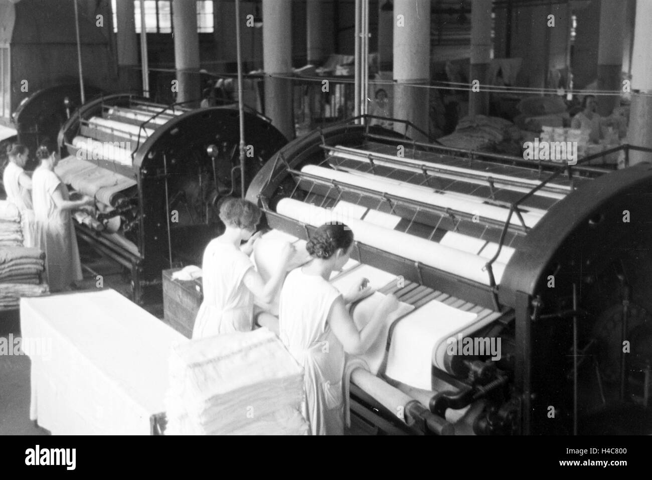 Mitarbeiterinnen der Mitropa beim Bügeln der Bezüge der Mitropa Reisekissen, Deutschland 1930er Jahre. Female staff members ironing the laundry of Mitropa travel pillows, Germany 1930s Stock Photo