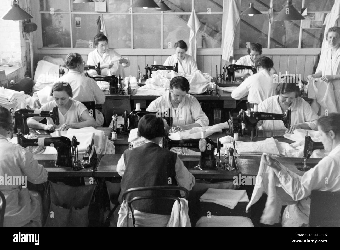 Näherinnen der Mitropa bei der Herstellung der Mitropa Reisekissen, Deutschland 1930er Jahre. Female staff members sewing Mitropa travel pillows, Germany 1930s Stock Photo
