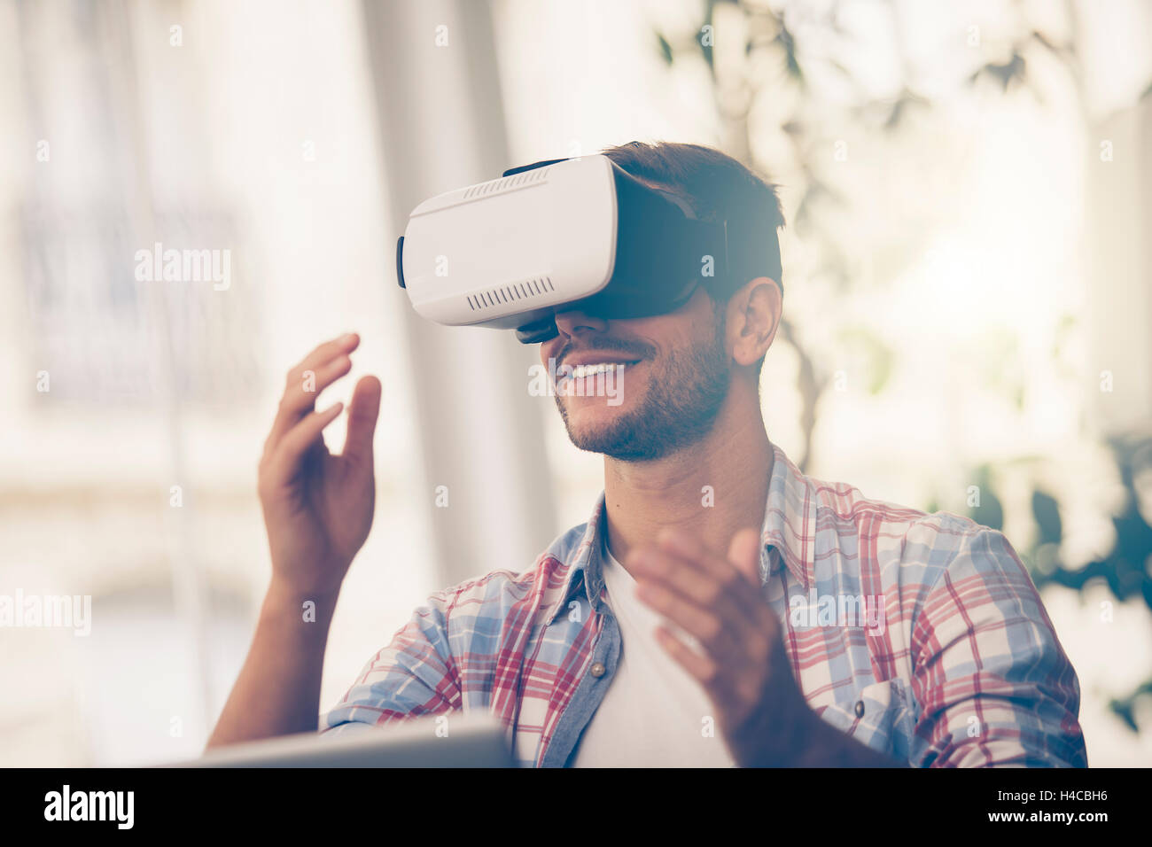 Entrepreneurs testing virtual reality technology with colleague in office. Stock Photo