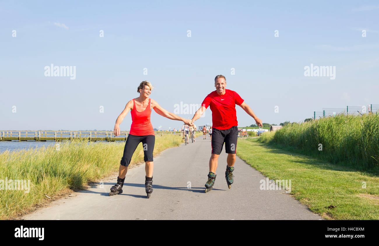 Man and woman go Inline skat by the sea Stock Photo