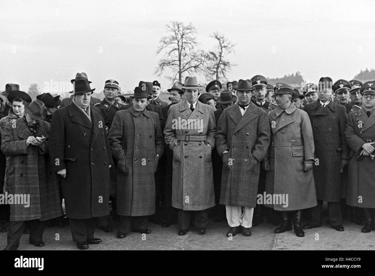 NS officials, celebrities and onlooker listen in to the speech of a NS dignitary in front of the world record attempt with Mercedes Benz W 125, Germany the 1930s. Nazi officials, celebrities and onlookers listening to the spreech of a Nazi dignitary in front of the start the world record trial with the Mercedes Benz W 125, Germany 1930see. Stock Photo