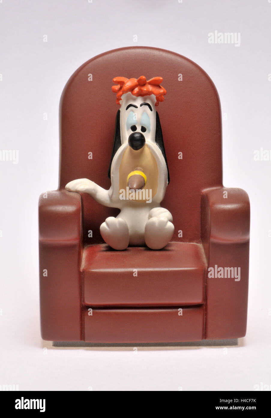 Cartoon character figurine - Droopy (MGM) sitting in an armchair, smoking a cigar Stock Photo