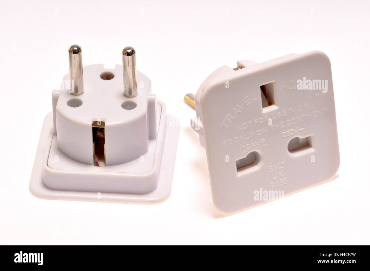 Travel plug adapter - for using a three pin UK plug in a two pin European socket Stock Photo