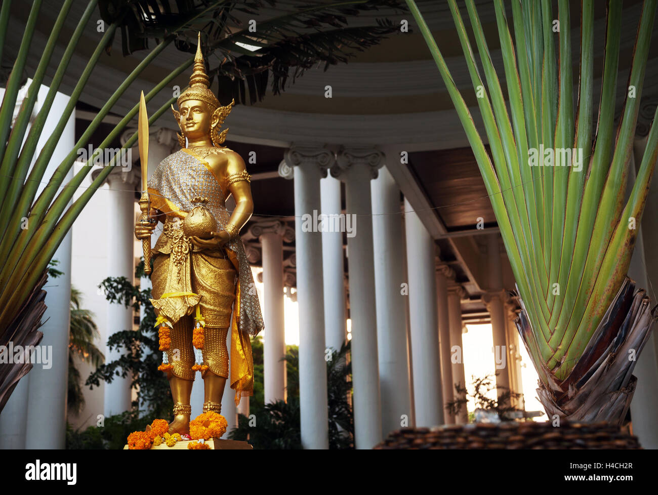 Golden Rama statue wearing traditional costume. Gold Hindu god sculpture holding sword and cloth sack Stock Photo