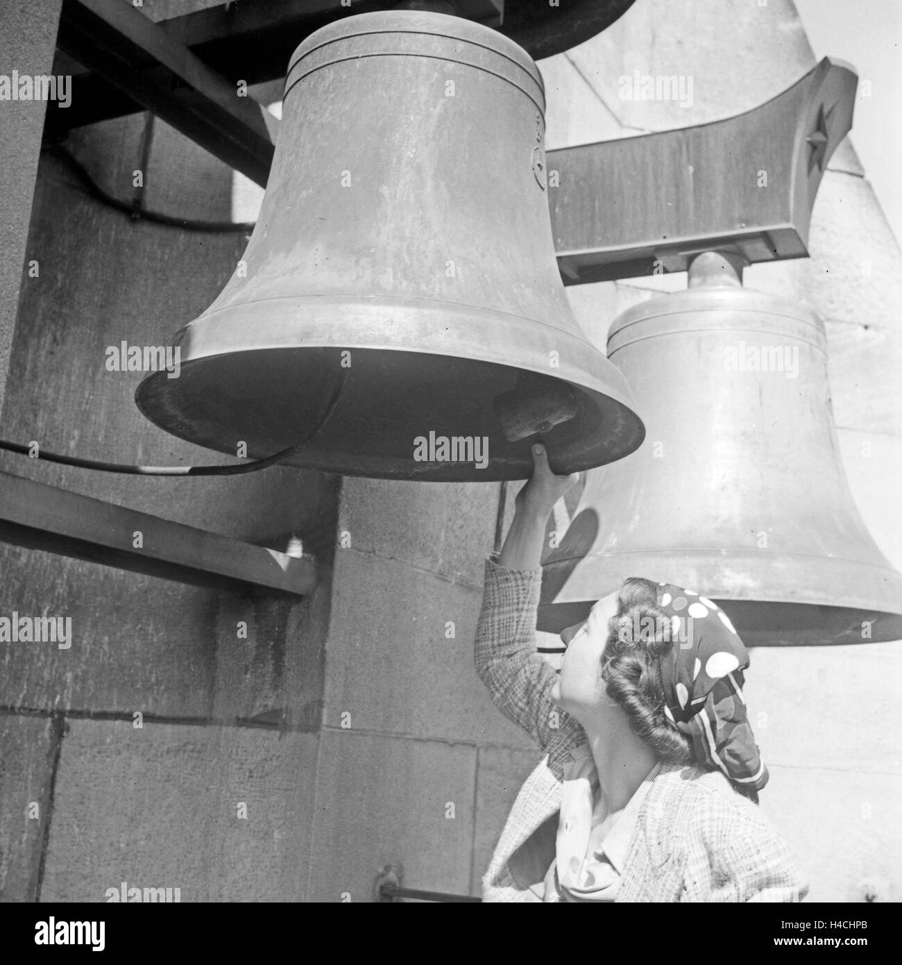 Eine Frau besieht sich eine Glocke des Geläuts am Rathuasturm in Stuttgart, Deutschland 1930er Jahre. A woman watching a bell of the chimes of city hall belfry at Stuttgart, Germany 1930s. Stock Photo