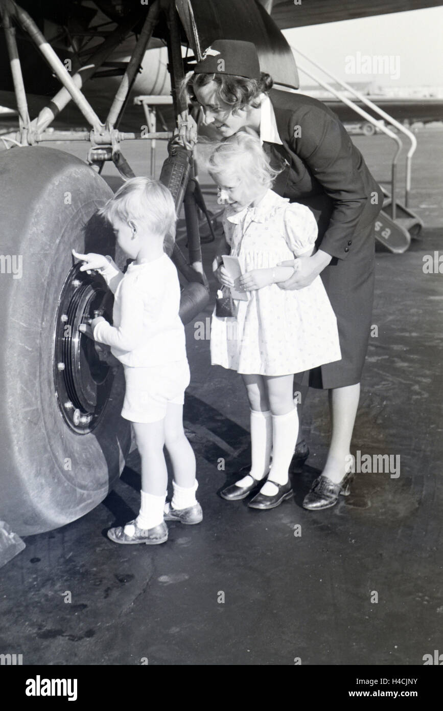 Stewardess zeigt und erklrt zwei Kindern einen Flugzeugreifen, Deutsches Reich 1930er Jahre. Stewardess showing and explaning an airplane tire to two children, Germany 1930s Stock Photo