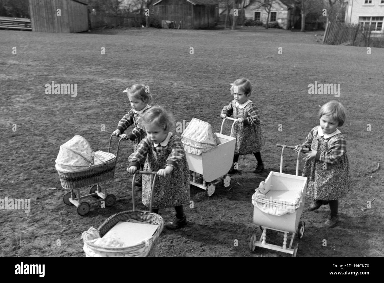 Die Knipser Vierlinge als Kleinkinder mit ihren Puppenwagen, Deutschland 1930er Jahre. Knipser's quadruplet girls with their doll's prams, Germany 1930s Stock Photo