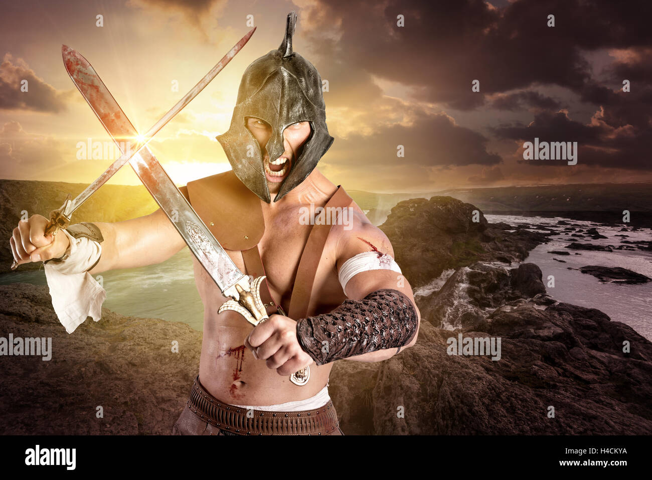 Gladiator or warrior posing with swords outdoors ready for battle Stock Photo