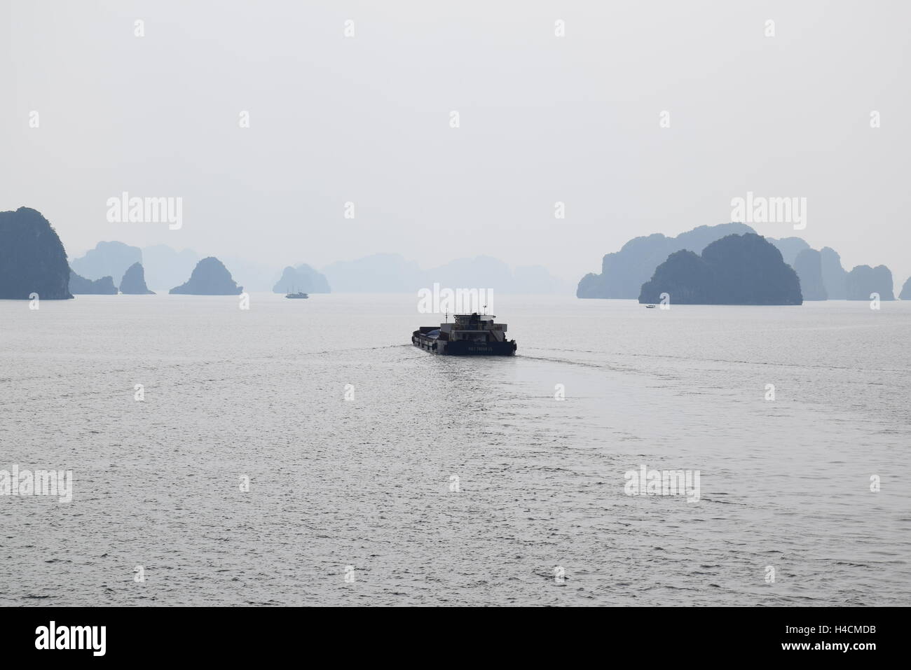 Boat floating on the river between the rocks of Halong bay, Vietnam Stock Photo