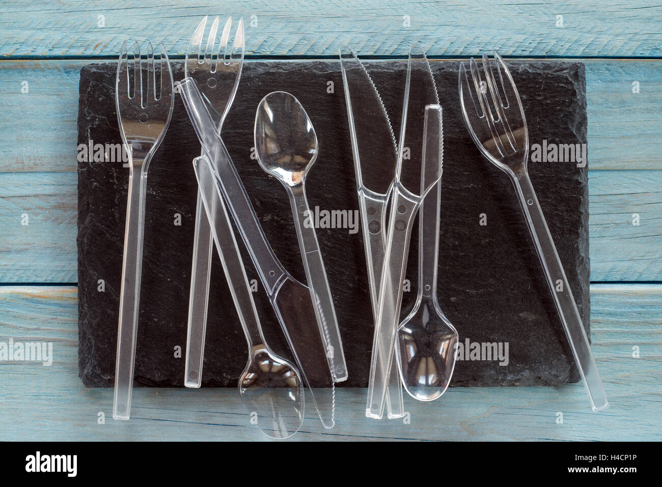 transparent plastic cutlery on black background Stock Photo