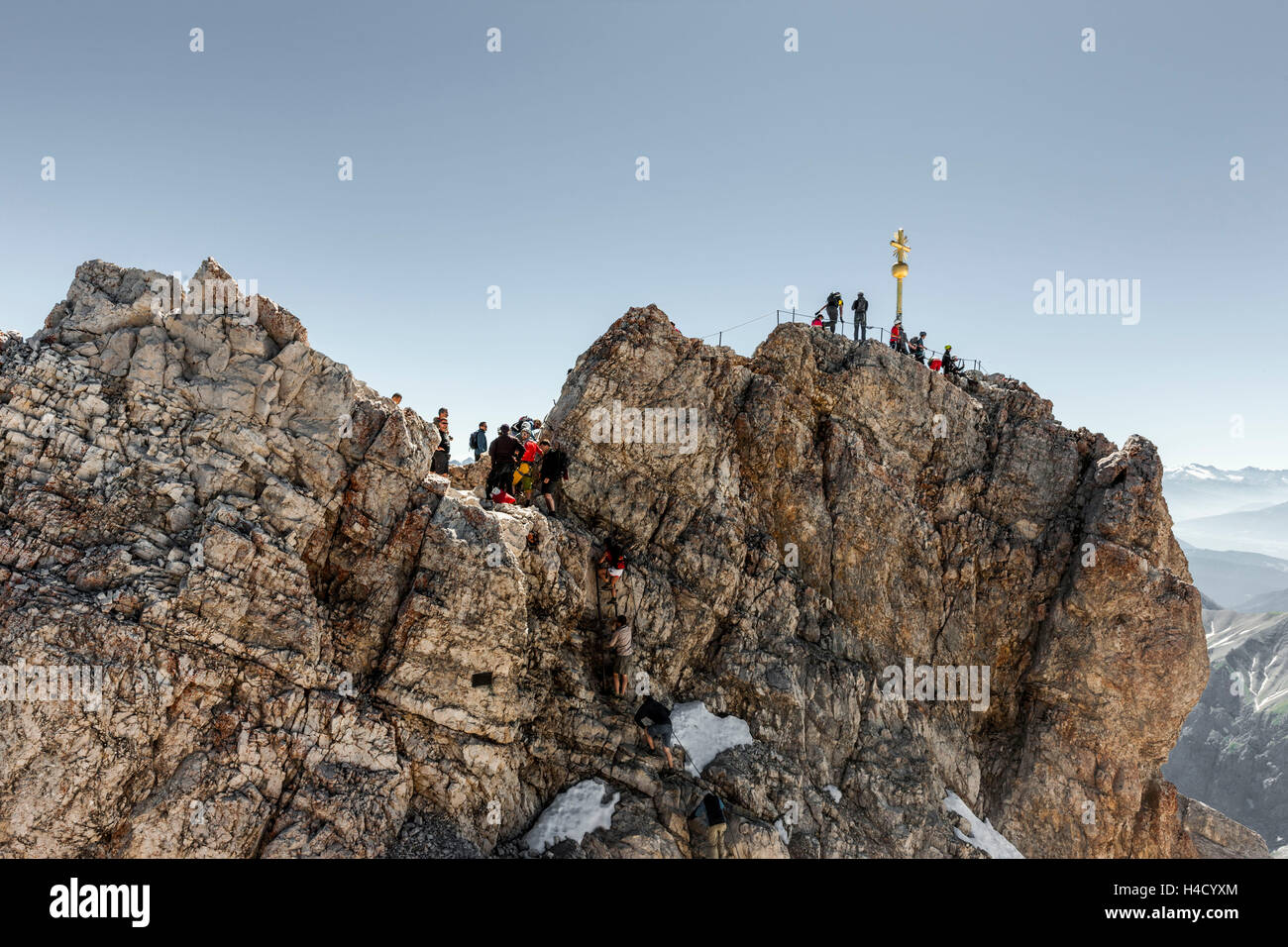 Mountaineer on the summit cross of 'Zugspitze' Stock Photo