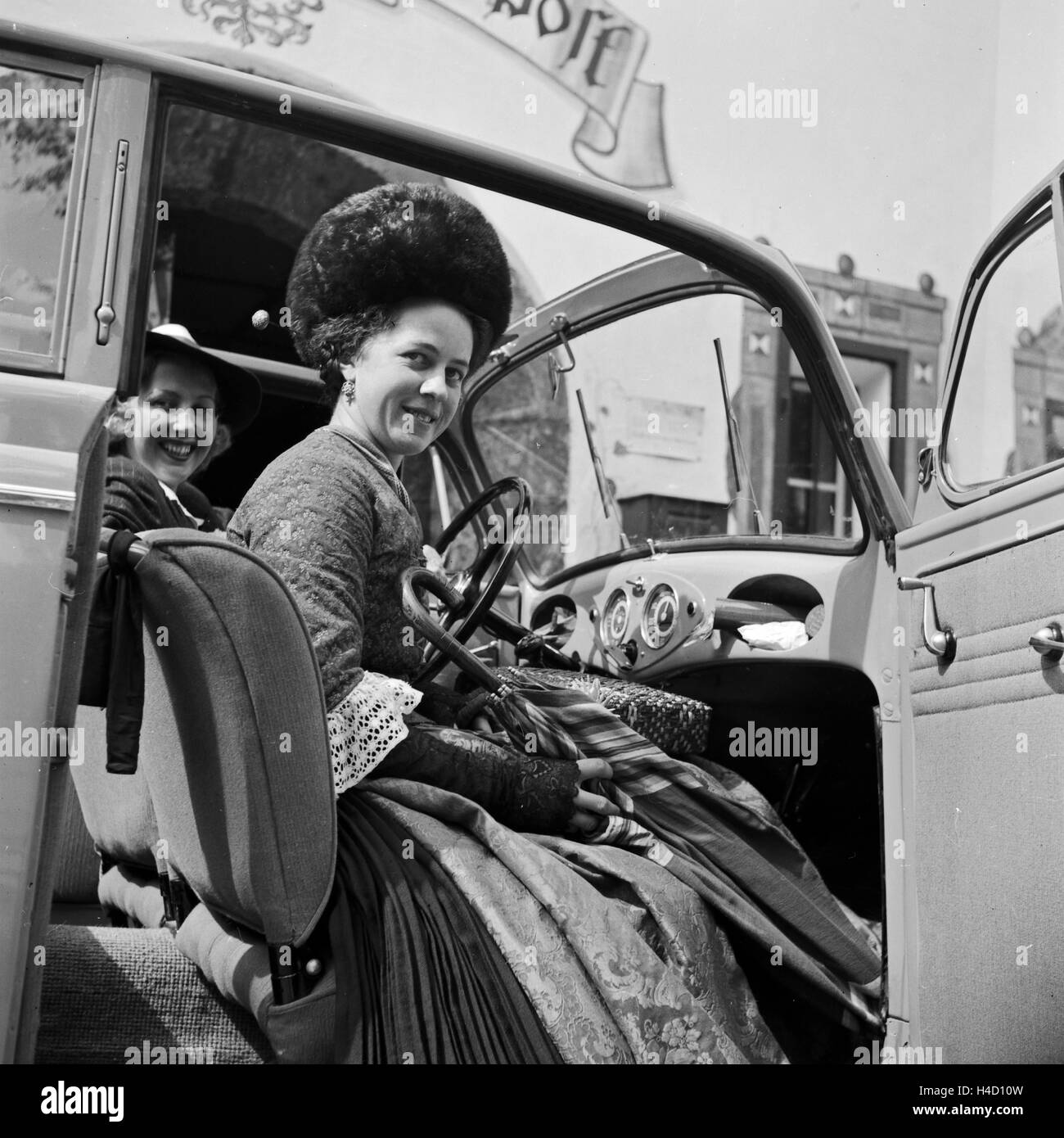 Zwei Frauen bekommen vor einem Hotel im Schwarzwald Getränke angeboten von einer Frau in Schwarzwälder Tracht, Deutschland 1930er Jahre. Two women getting a drink by a woman in Black Forest array, Germany 1930s. Stock Photo