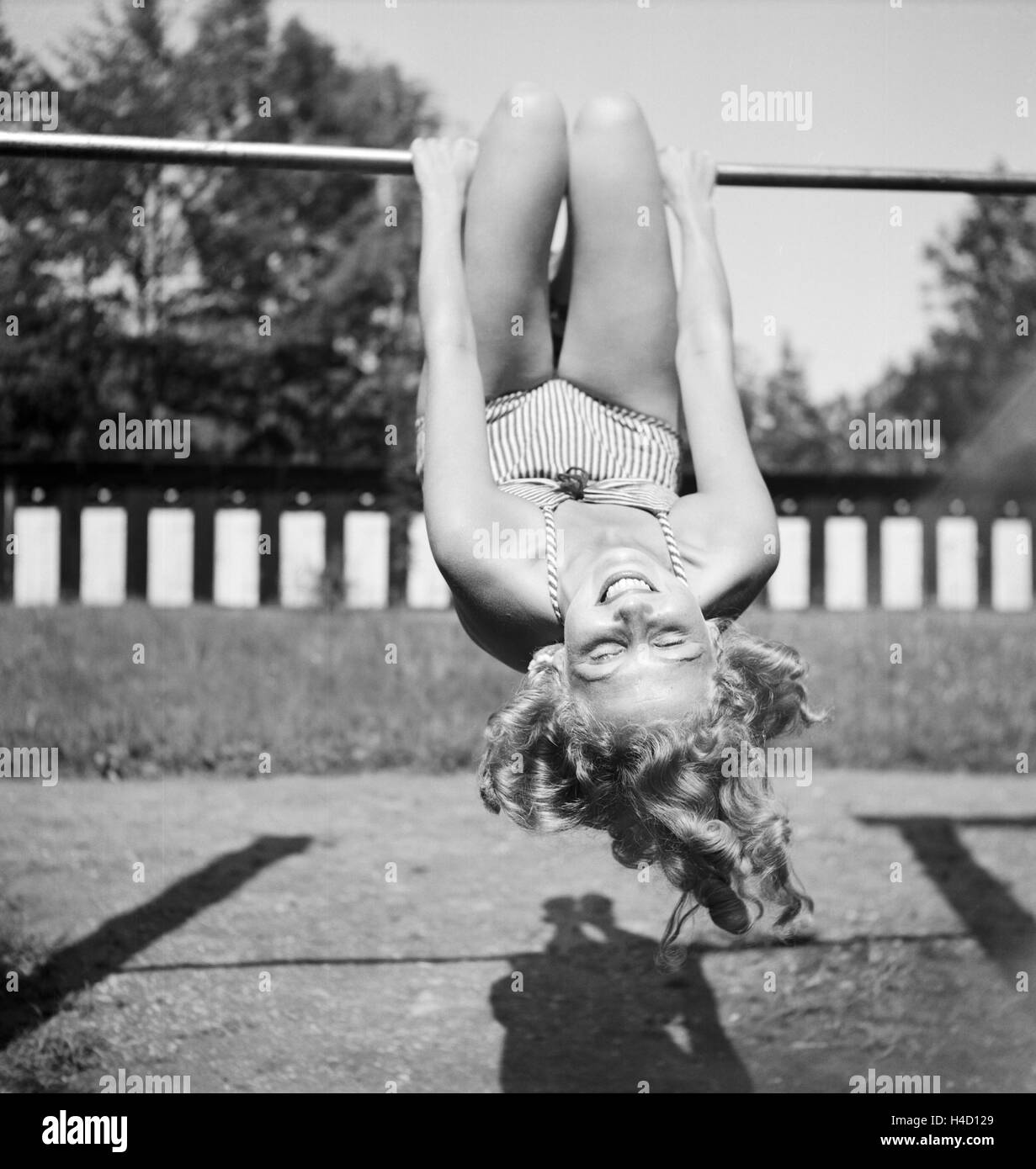 Eine junge Frau turnt auf einem Spielplatz in der Wachau in Österreich, Deutschland 1930er Jahre. A young woman doing gymnastics on a playground in the Wachau area in Austria, Germany 1930s. Stock Photo