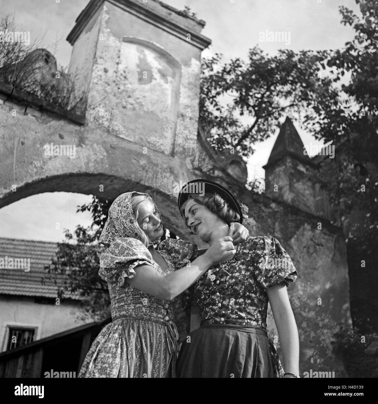 Zwei junge Frauen in Landhausmode vor einem alten Portal, Österreich 1930er  Jahre. Two young women wearing countryside fashion in front of an old gate,  Austria 1930s Stock Photo - Alamy
