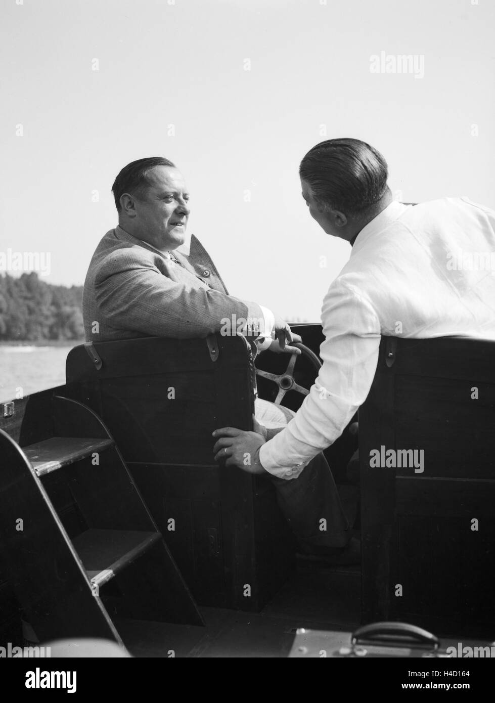 Ein Mann unterwegs in seinem Motorboot auf einem See, Deutschland 1930er Jahre. A man on a lake in his motor boar, Germany 1930s. Stock Photo