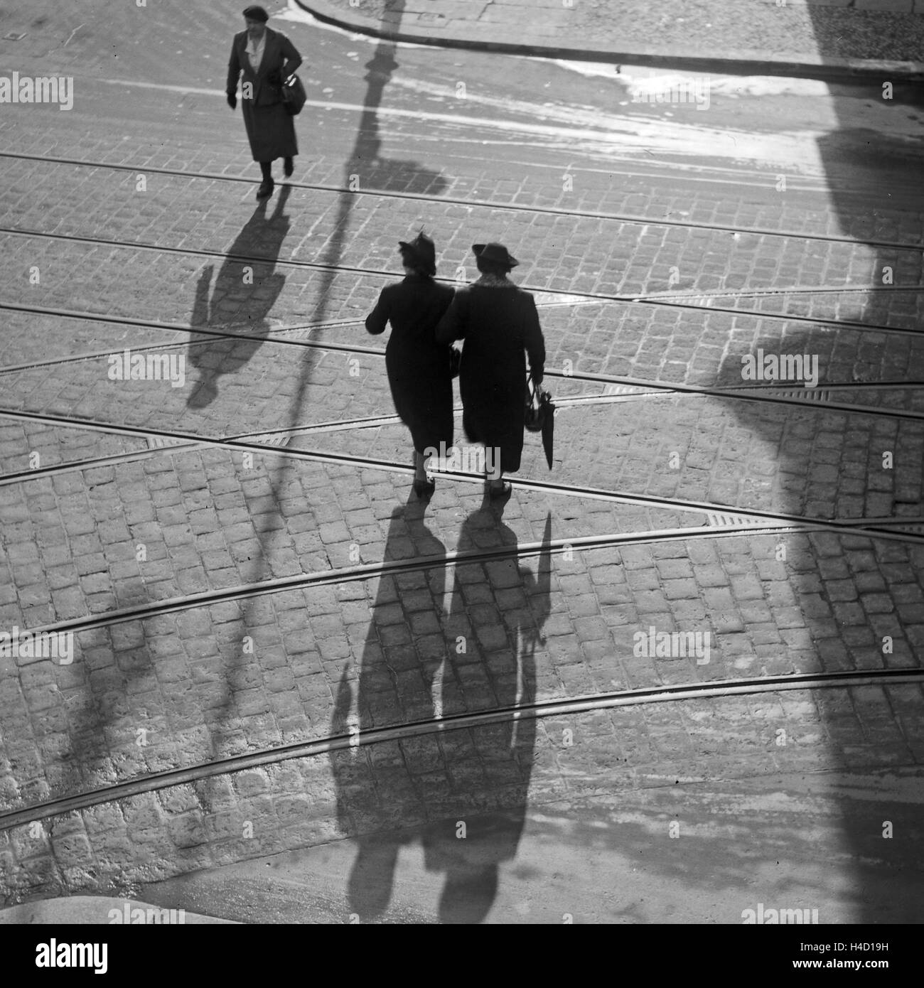 Die Menschen in Berlin werfen lange Schatten, Deutschland 1930er Jahre. people at a street in Berlin with their shadows, Germany 1930s. Stock Photo