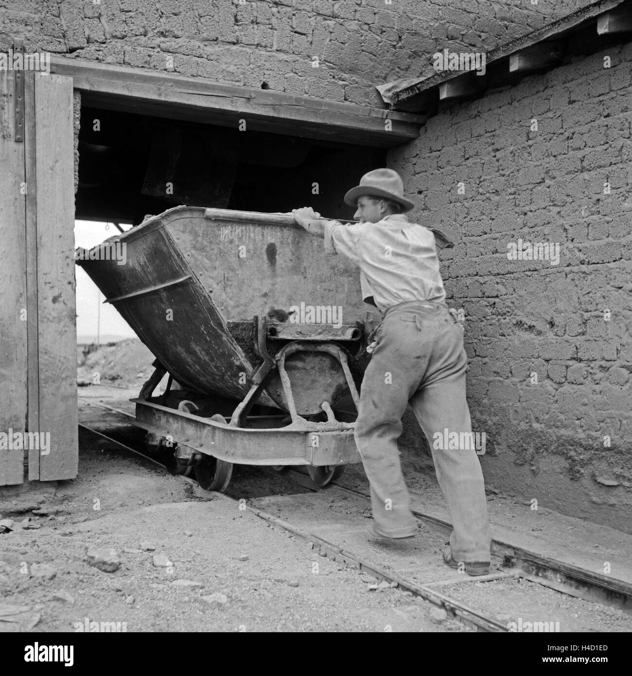 Ein Arbeiter holt mit einer Kipplore Schlemmstein, Deutschland 1930er Jahre. Worker taking Rhenish bricks with a lorry from the stone pit, Germany 1930s. Stock Photo