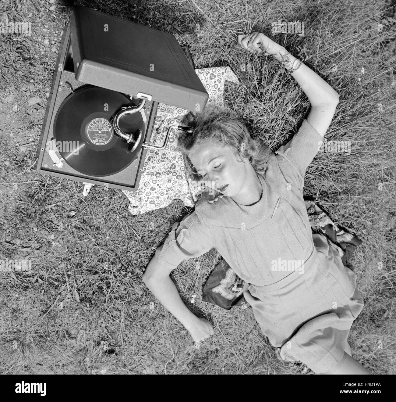 Eine junge Frau mit dem Electrola Koffer Grammofon und hört das Stück  "Frühlingstag" von Barnabas von Geczy, Österreich 1930er Jahre. A young  woman with an Electrola gramophone and an Electrola shellac record,