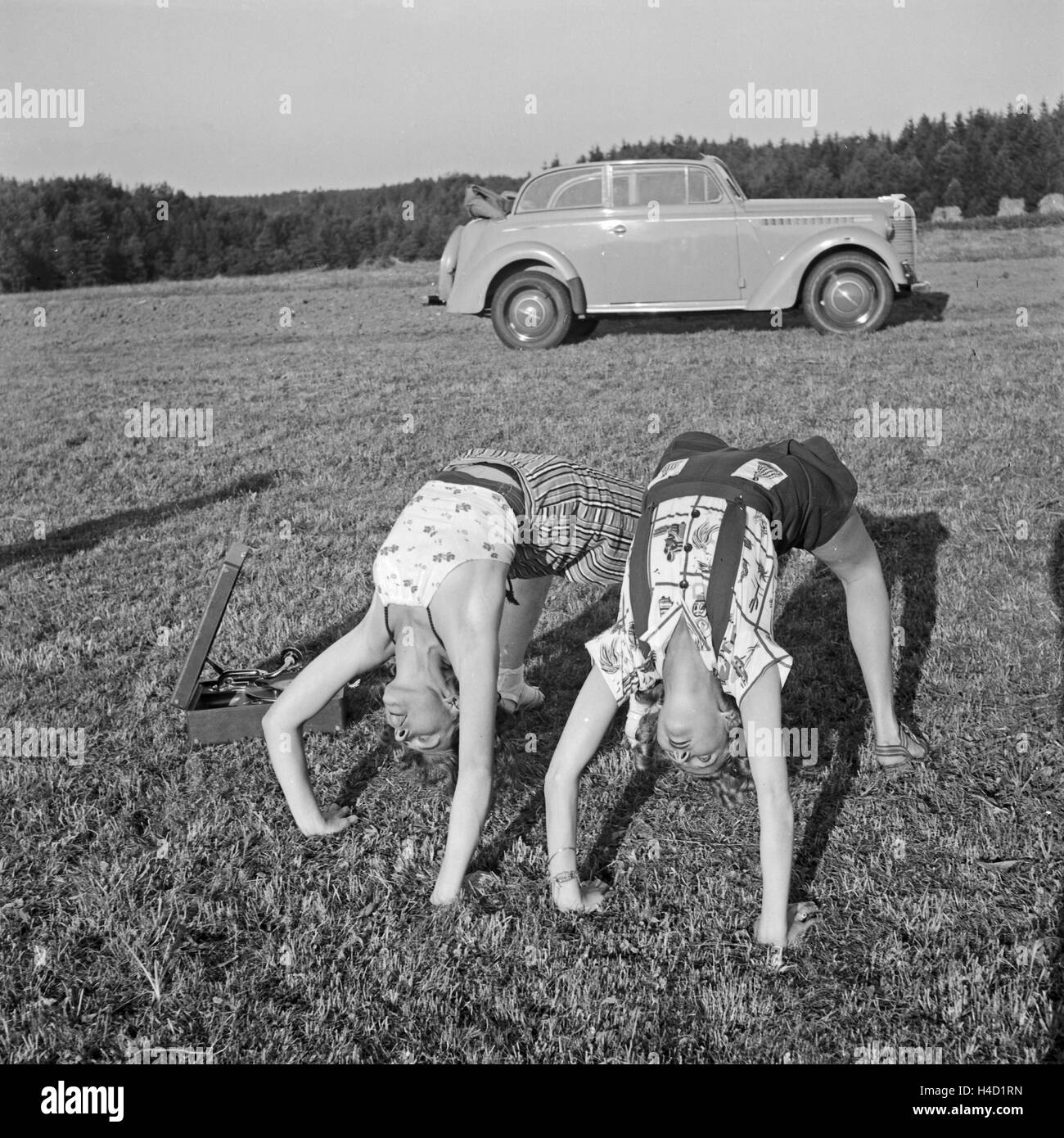 Frauen bei der Gymnastik auf einer Wiese, Deutschland 1930er Jahre. Women doing gymnastics on a lawn, Germany 1930s. Stock Photo