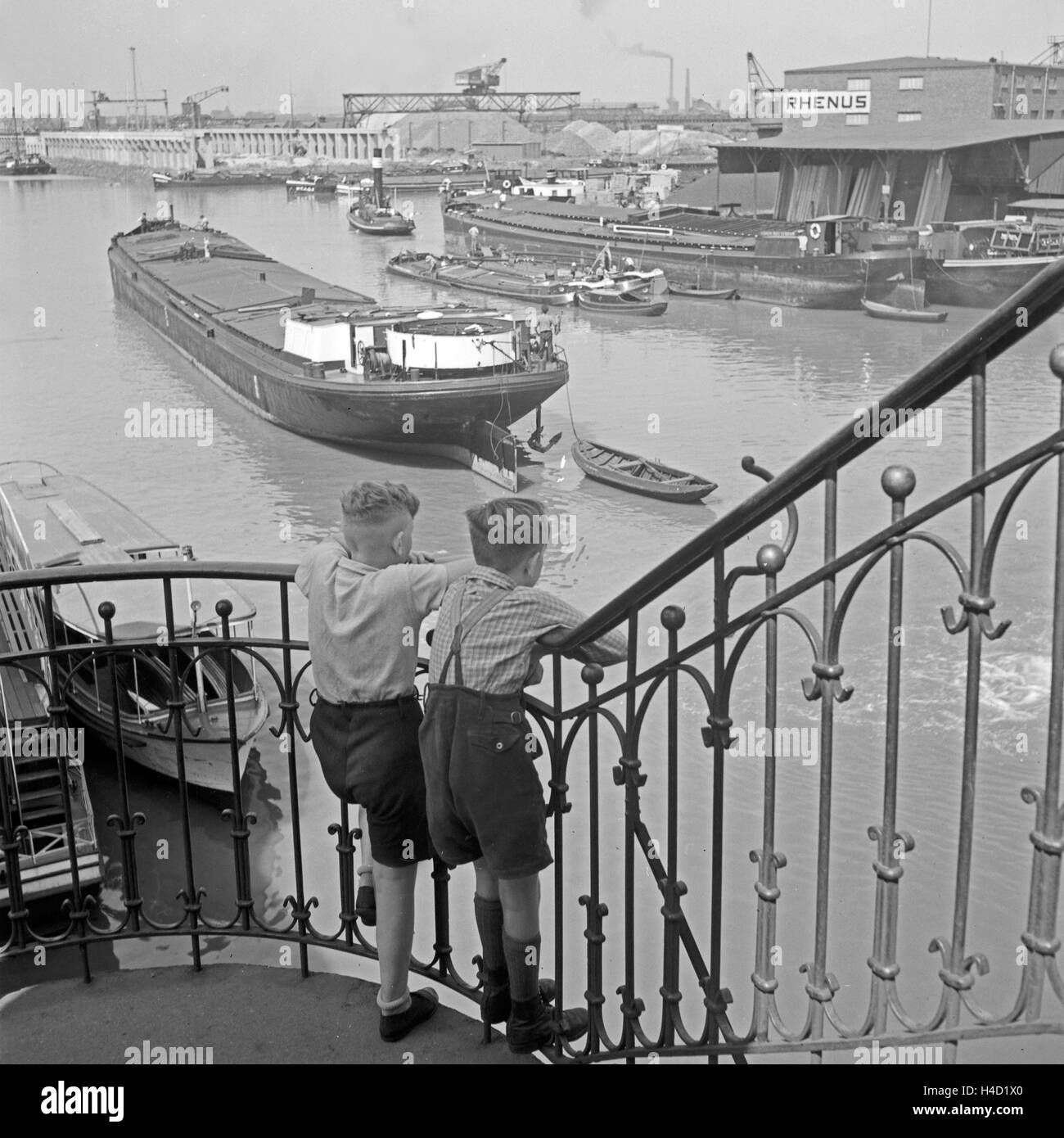 Zwei kleine Jungen schauen von einem Treppengeländer auf den Hafen von Dortmund, Deutschland 1930er Jahre. Two little boys watching Dortmund harbor from a banister rail, Germany 1930s. Stock Photo