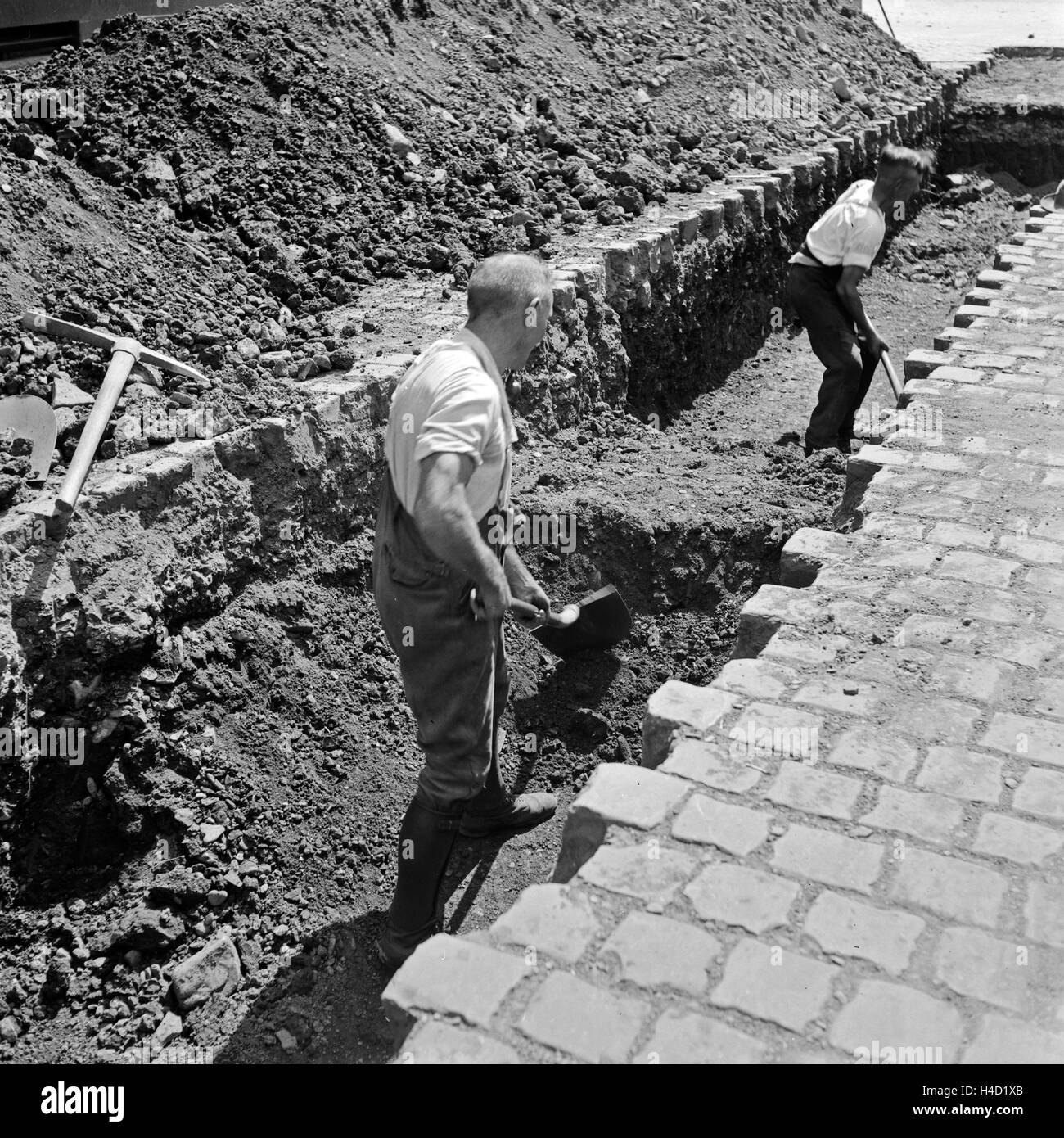 Bauarbeiter graben in einer Straße in Wuppertal, Deutschland 1930er Jahre. Construction workers digging at a construction area in Wuppertal, 1930s. Stock Photo