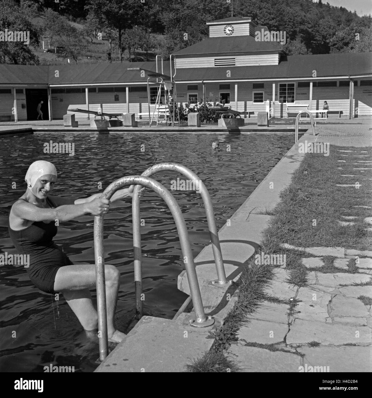 Eine Frau steigt aus dem Schwimmbecken im Kurbad von Wildbad im Schwarzwald, Deutschland 1930er Jahre. A woman getting off the water at spa bath Wildbad in Black Forest, Germany 1930s. Stock Photo