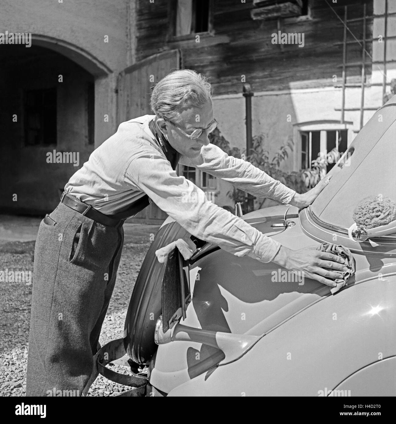 Der Fotograf Karl Heinrich Lämmel beim Wagenwaschen, Deutschland 1930er Jahre. The photographer Karl Heinrich Laemmel doing the car wash, Germany 1930s. Stock Photo