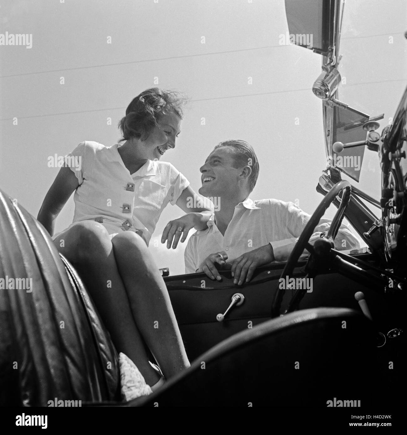 Ein junger Mann und eine junge Frau an einem Ford V8 Cabrio, Deutschland 1930er Jahre. A young man and a young woman with a Ford V8 convertible, Germany 1930s. Stock Photo