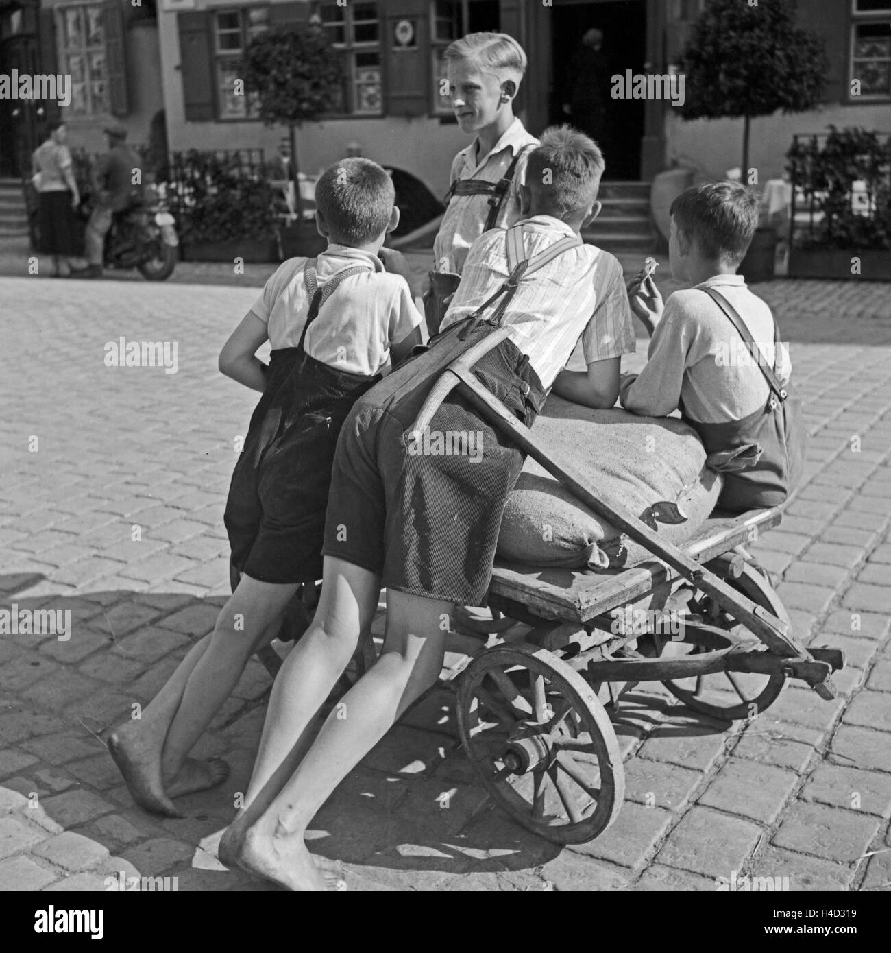 Jungen mit einem Handkarren in einer Straße in Dinkelsbühl, Deutschland 1930er Jahre. Boys with a push cart in a street of Dinkelsbuehl. Germany 1930s. Stock Photo