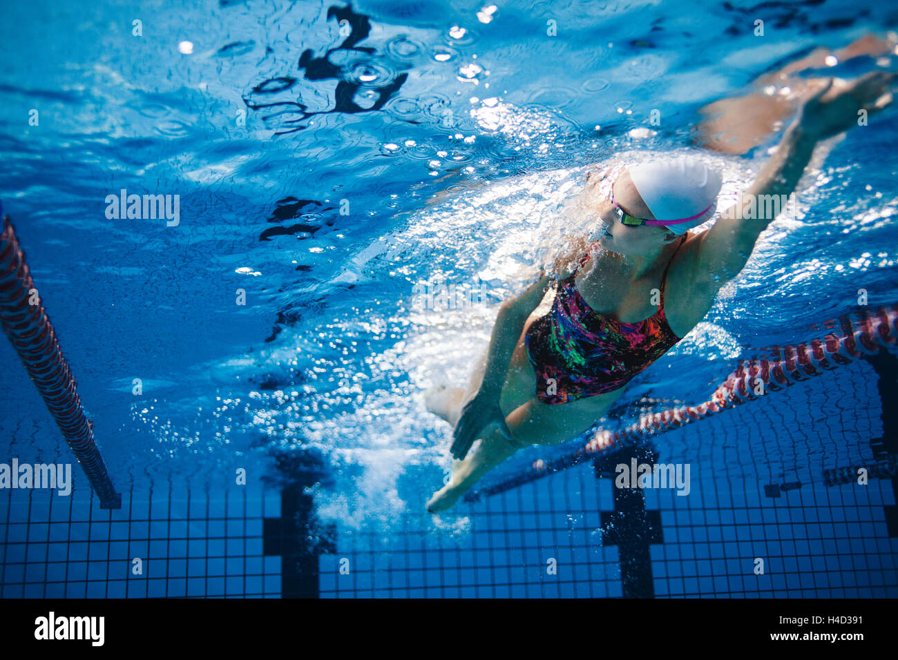 Underwater shot of fit swimmer training in the pool. Female swimmer inside swimming pool. Stock Photo