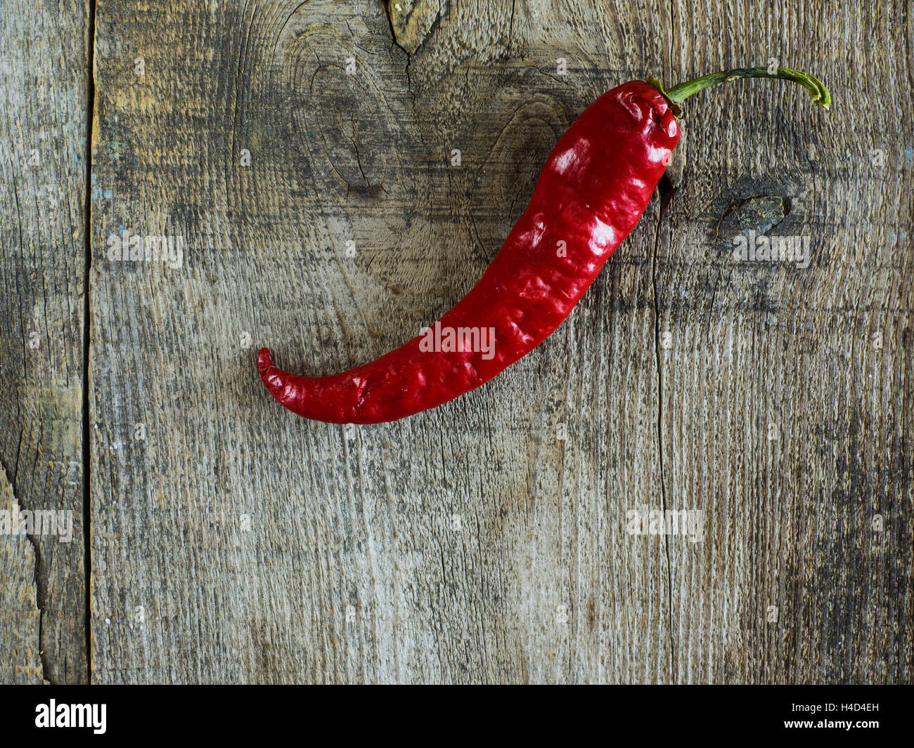 Red hot chili pepper on old wooden weathering table Stock Photo - Alamy
