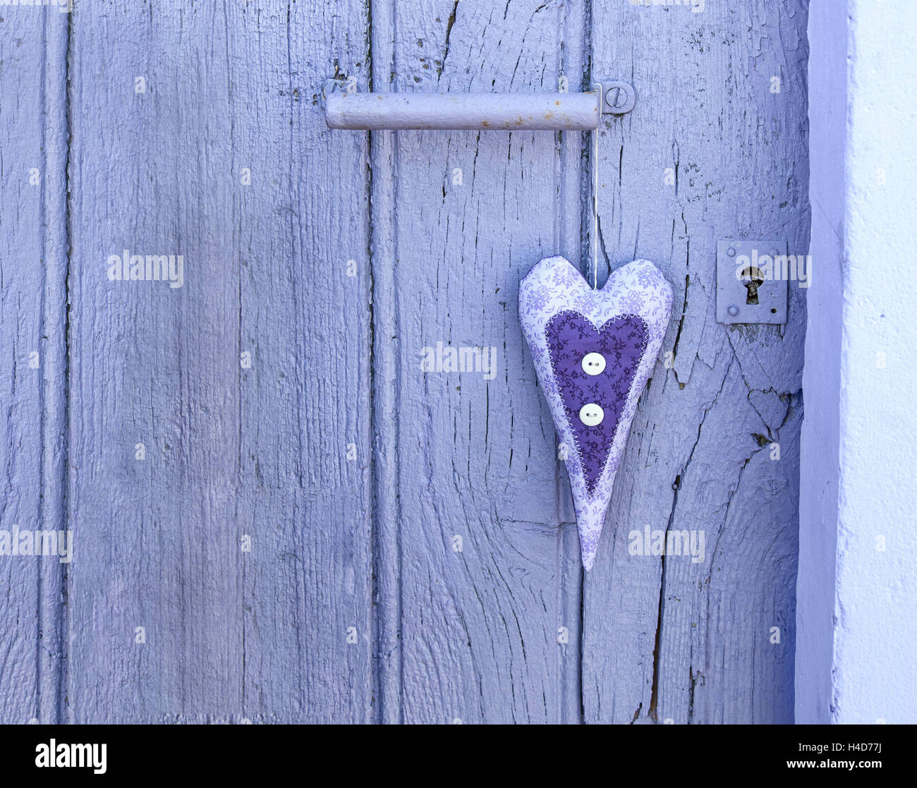 fabric heart hanging in old door Stock Photo