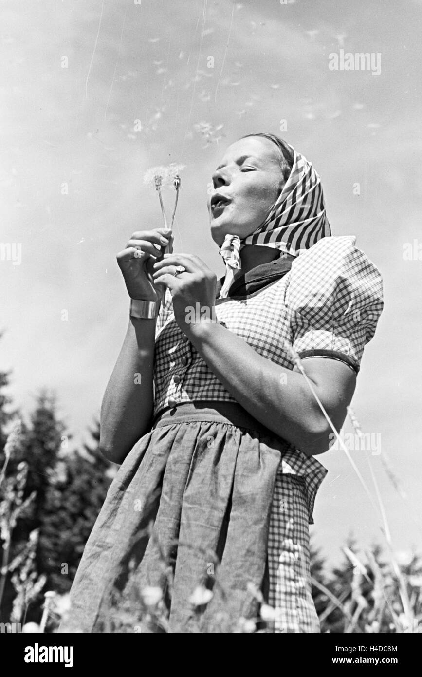Porträt einer jungen Frau auf einer Blumenwiese, Freudenstadt, Deutschland 1930er Jahre. Portrait of a young woman on a flower field, Freudenstadt, Germany 1930s. Stock Photo